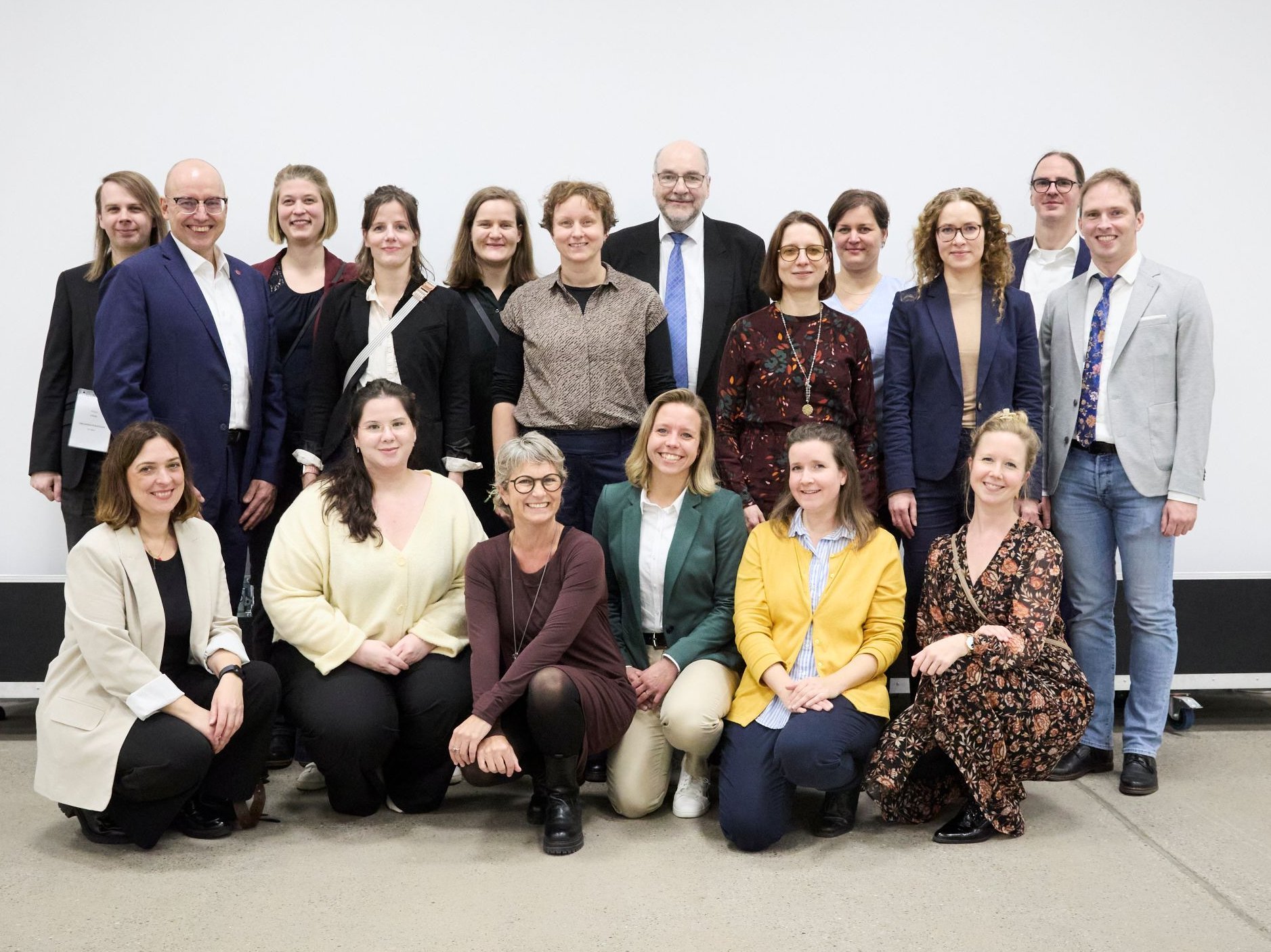 Gruppenfoto der Mitarbeitenden des PK NRW, die gemeinsam in die Kamera lächeln und mit dem Bild ihre Weihnachts- und Neujahrsgrüße übermitteln.